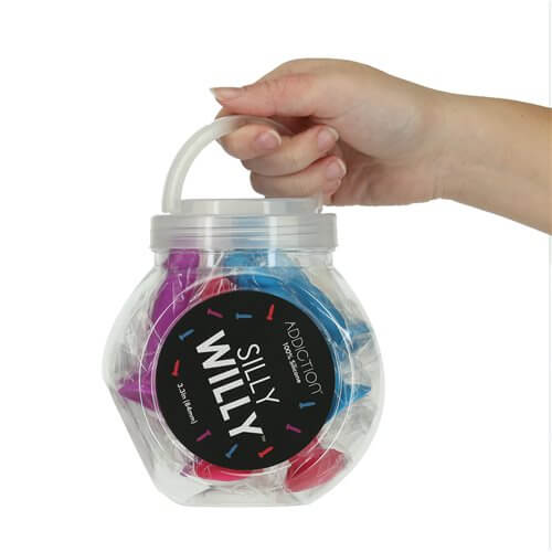 A person holding a jar of Addiction Silly Willy Glow in the Dark Mini Dongs, showcasing fun-colored dongs.