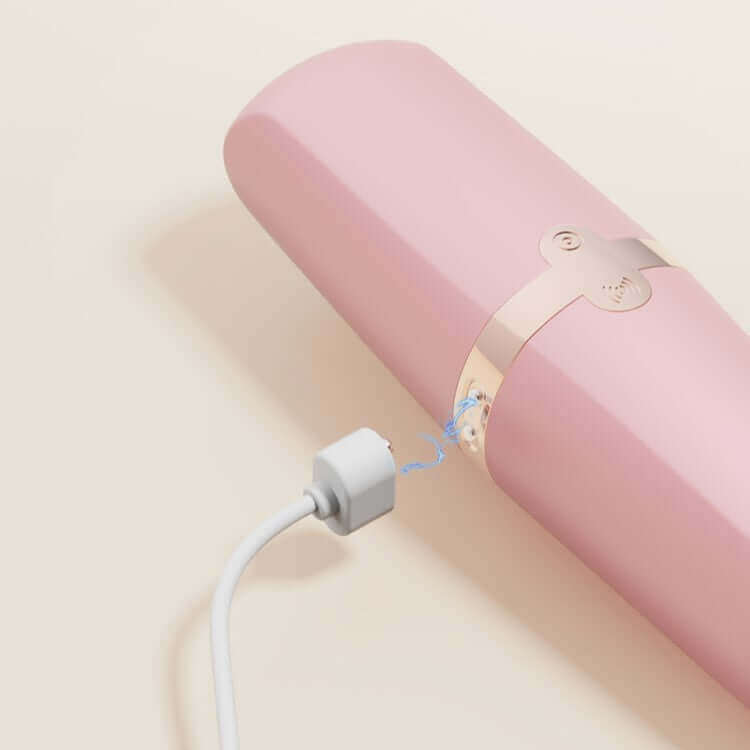 Sweet Secret Dual Massager Pink charging with USB cable on a light background.