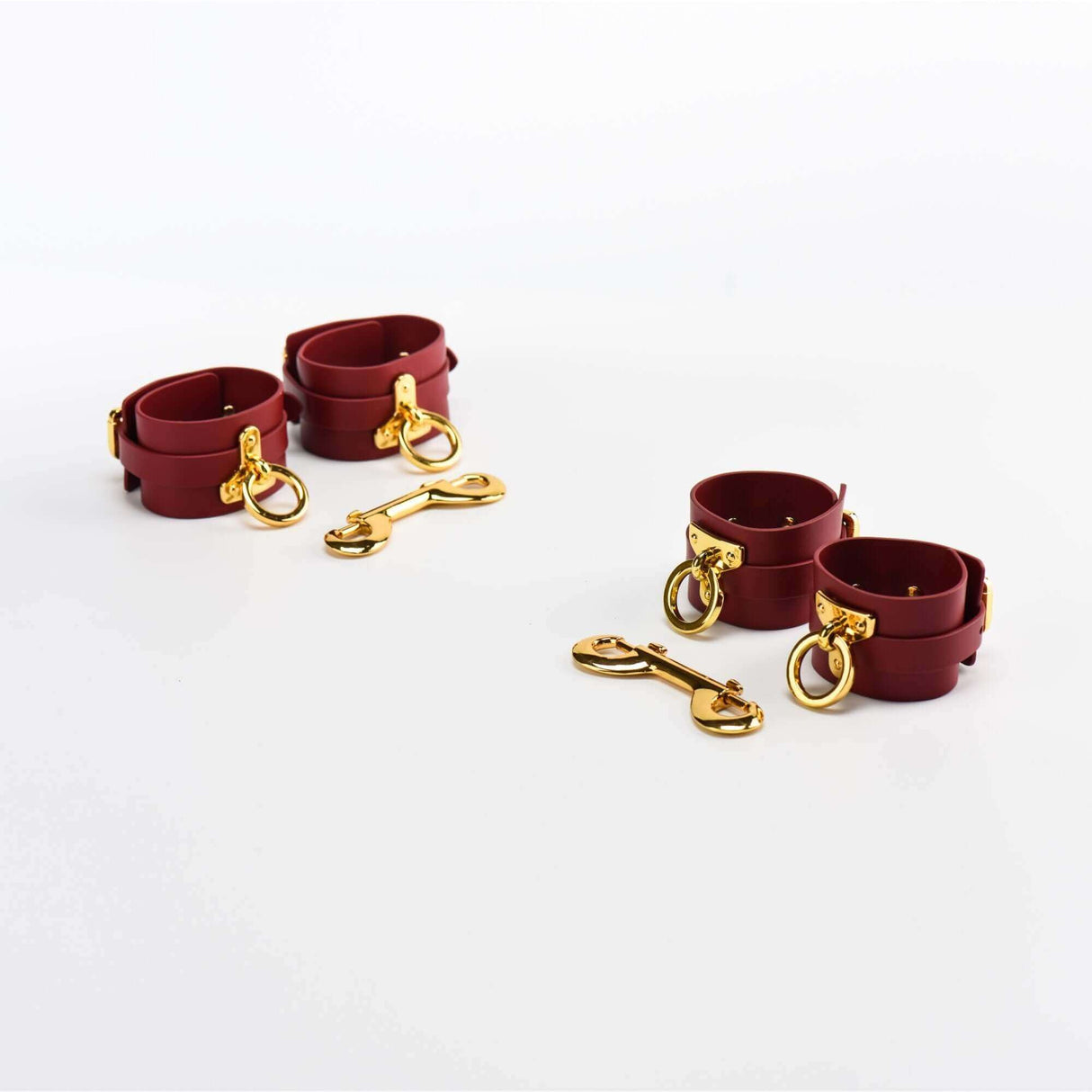 Red Italian leather wrist cuffs and leash set with gold accents for BDSM adventures.