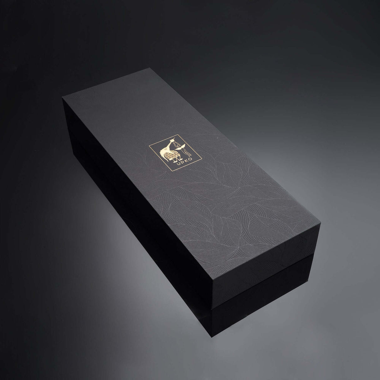 Elegant black gift box with a gold logo, featuring a textured floral design, ideal for luxury packaging.