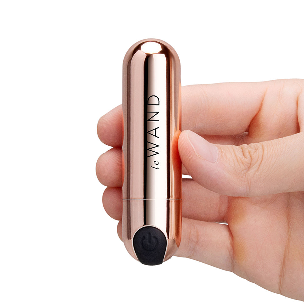 Le Wand Essentials Mini Rose Gold Bullet Vibrator held in hand, showcasing sleek design and compact size.