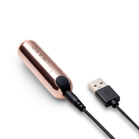 Le Wand Essentials Mini Rose Gold Bullet Vibrator with charging cable, showcasing sleek design and portability.