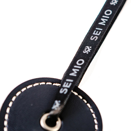 Close-up of Sei Mio Double Trouble Shhh Oops Double-Sided Paddle tag showcasing branding and craftsmanship.