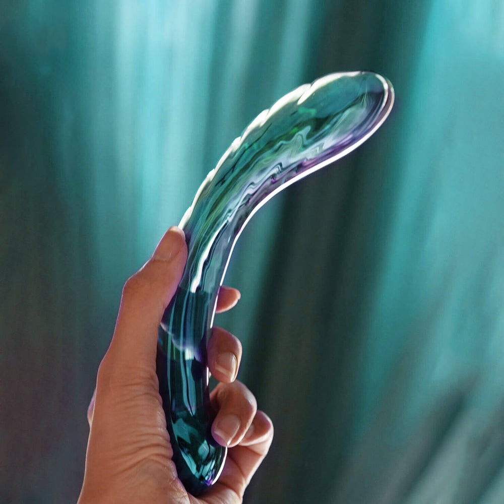 Biird Kalii Glass G-spot Dildo held in hand showcasing its elegant teal design.