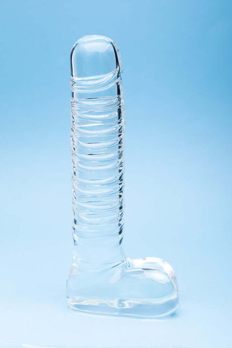 Clarity Seraphic Opus Glass Dildo on a blue background, showcasing its elegant design and handblown craftsmanship.