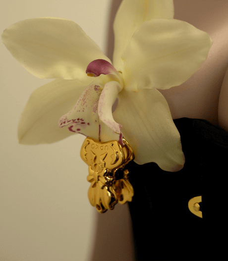 Elegant bowknot binder clip style nipple clamps adorned with a yellow orchid, showcasing unique design and intricate details.