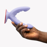Fun Factory Ryde Grinding Dildo Purple held in hand, showcasing the design for vaginal, anal, and clitoral stimulation.