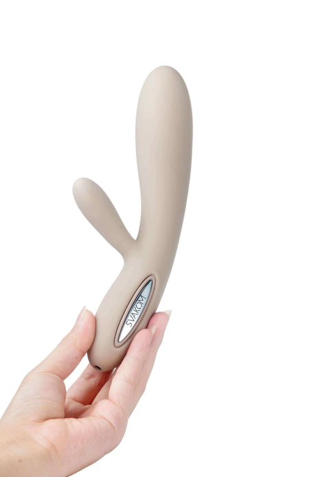 Svakom Lester Rechargeable Warming Rabbit Vibrator Khaki held in hand, showcasing its sleek design and premium material.