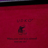 UPKO logo and quote on a pink surface, featuring playful imagery and a whimsical message about passion and turmoil.