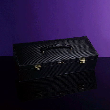 UPKO luxury black bondage case with handle, reflecting on a surface against a purple background.