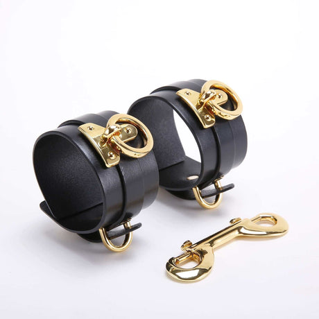 UPKO black leather wrist cuffs with gold hardware, part of the luxury bondage tools set for BDSM play.