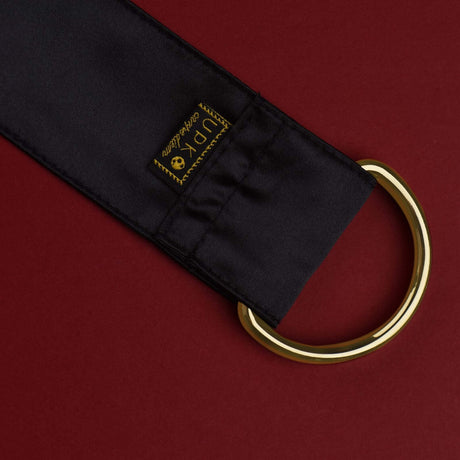 UPKO Carpe Diem silk strap with gold ring, perfect for bondage and restraint play. Premium quality design on red background.