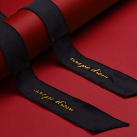 Carpe Diem premium silk ribbon in black with gold lettering on a red background, part of a bondage set.