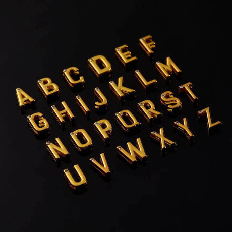 24-karat gold-plated alphabet letters with crystals for personalized jewelry on black background
