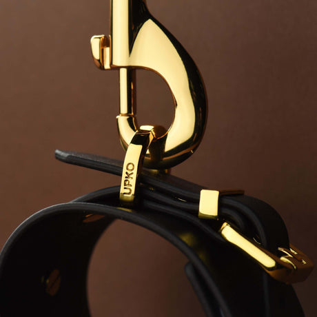 FUCK ME Luxury Italian Leather Handcuffs by UPKO close-up showing gold hardware and quality craftsmanship.