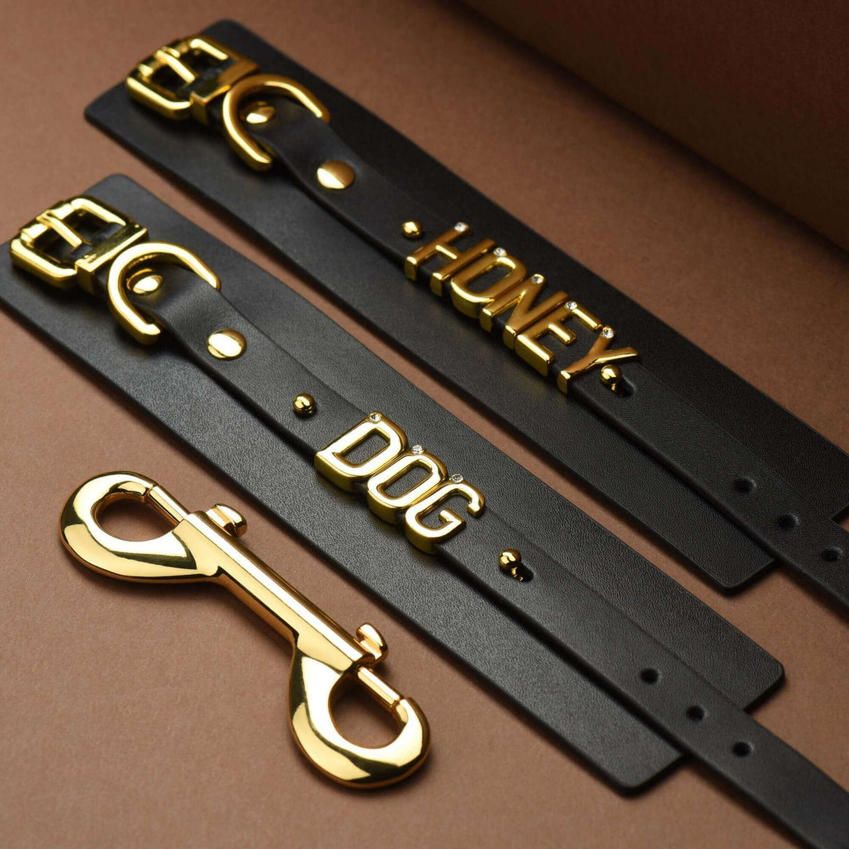 FUCK ME Luxury Italian Leather Handcuffs by UPKO featuring gold lettering and clasps on black leather straps.