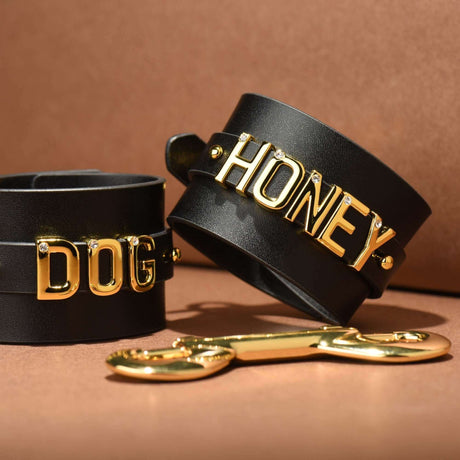 FUCK ME Luxury Italian Leather Handcuffs by UPKO with gold accents on black leather, featuring the words DOG and HONEY.