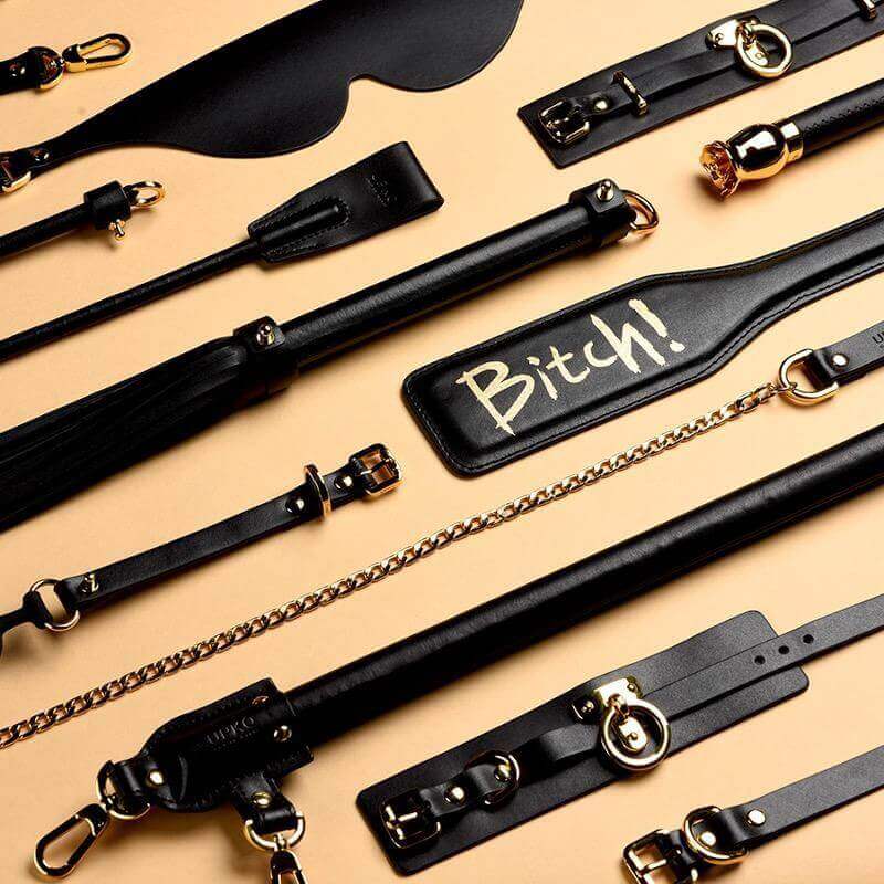 Assortment of luxury BDSM tools, including leather paddles and restraints, designed for high-end SM play.
