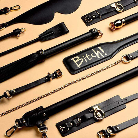 Assortment of luxury BDSM tools, including leather paddles and restraints, designed for high-end SM play.