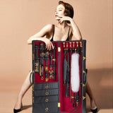 Woman showcasing the UPKO Luxury BDSM 15-piece Sade Trunk Kit with stylish SM tools in an elegant trunk.