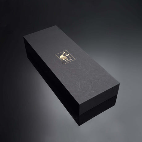 Elegant black gift box with a gold logo, featuring a textured floral design, ideal for luxury packaging.