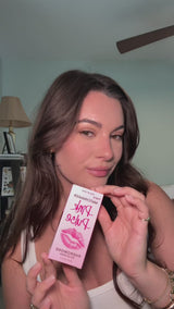Eye Of Love Matchmaker Pink Pulse Pheromone pH Lip Stain packaging held by a woman with a soft and polished look.