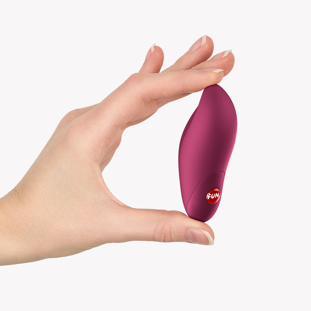 Fun Factory Charme Bullet Vibrator Wine Red held in hand, showcasing its compact design and tapered tip for precision.